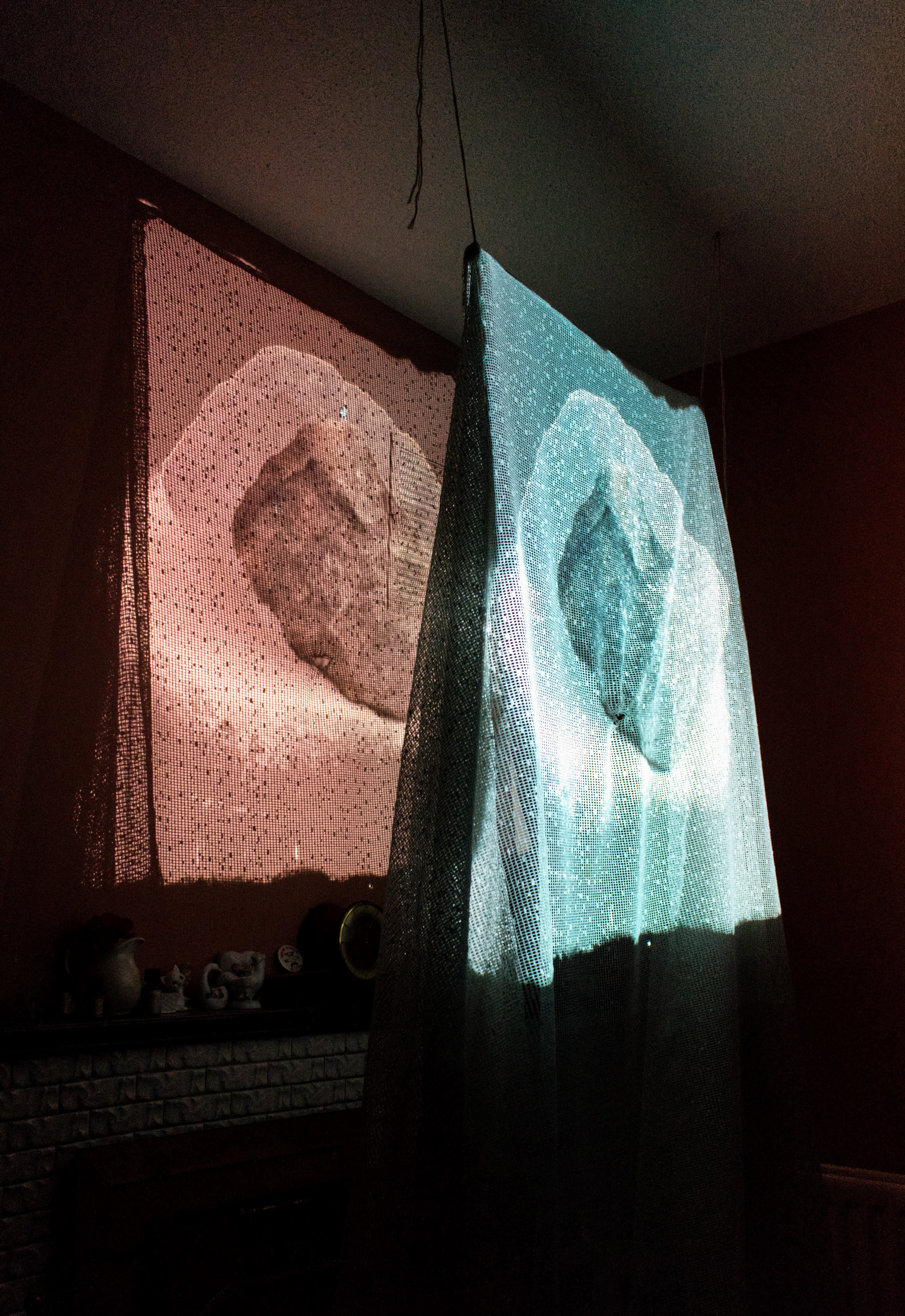 A still from a video of algorithimically generated stones projected onto a lace mesh